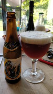 A bottle of St. Bernandus beer poured into a glass.