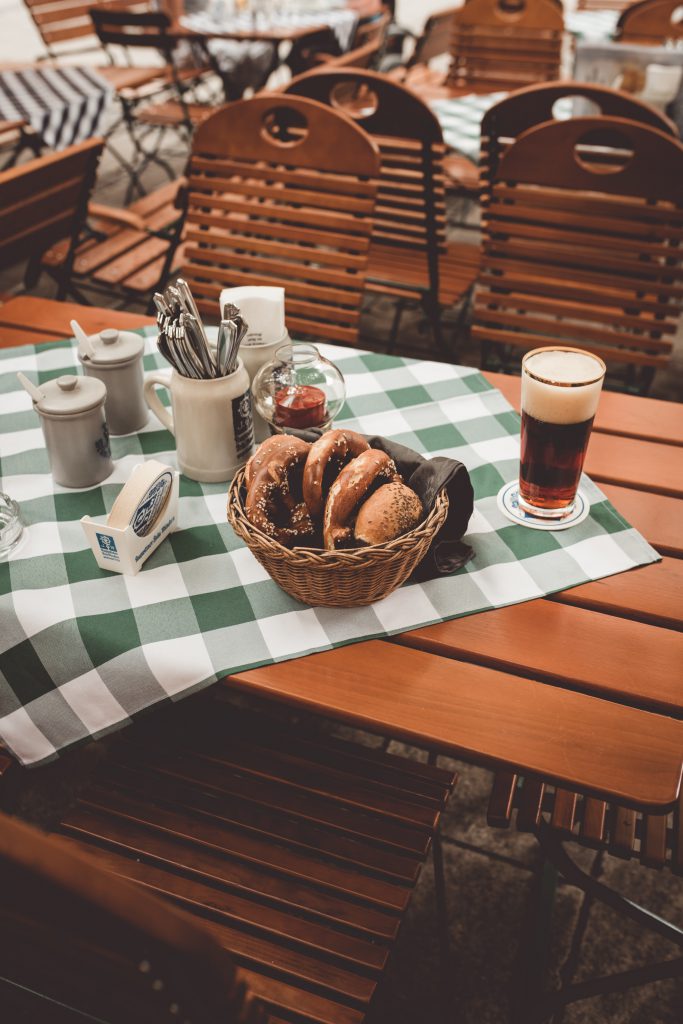 A table with beer and a basket of pretzels.