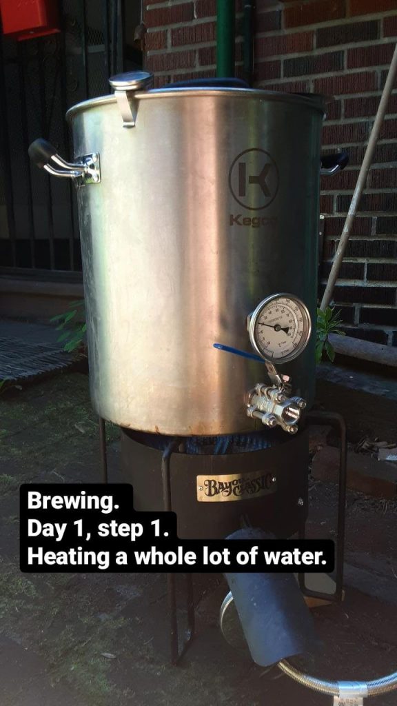 Picture of a big, 10 gallon pot on a gas burner. Text: Brewing. Day 1, step 1. Heating a whole lot of water.