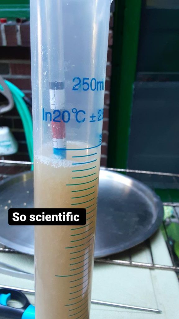 Picture of some beer in a graduated cylinder with a specific gravity measurement device. Text: So scientific